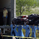 Police carry another victim from the shocking scene.